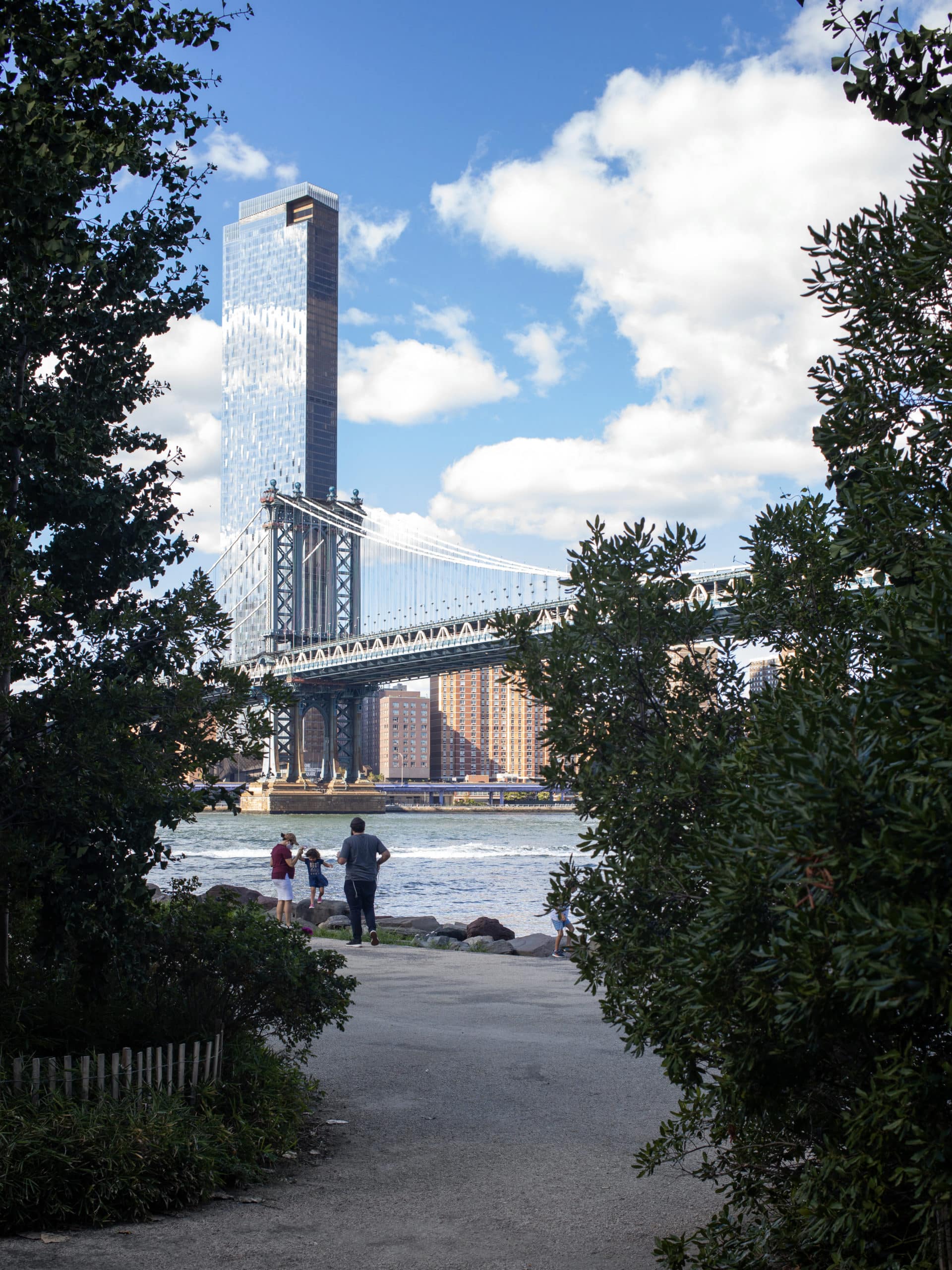 View from pathway of Manhattan Bridge and One Manhattan Square on a sunny day.