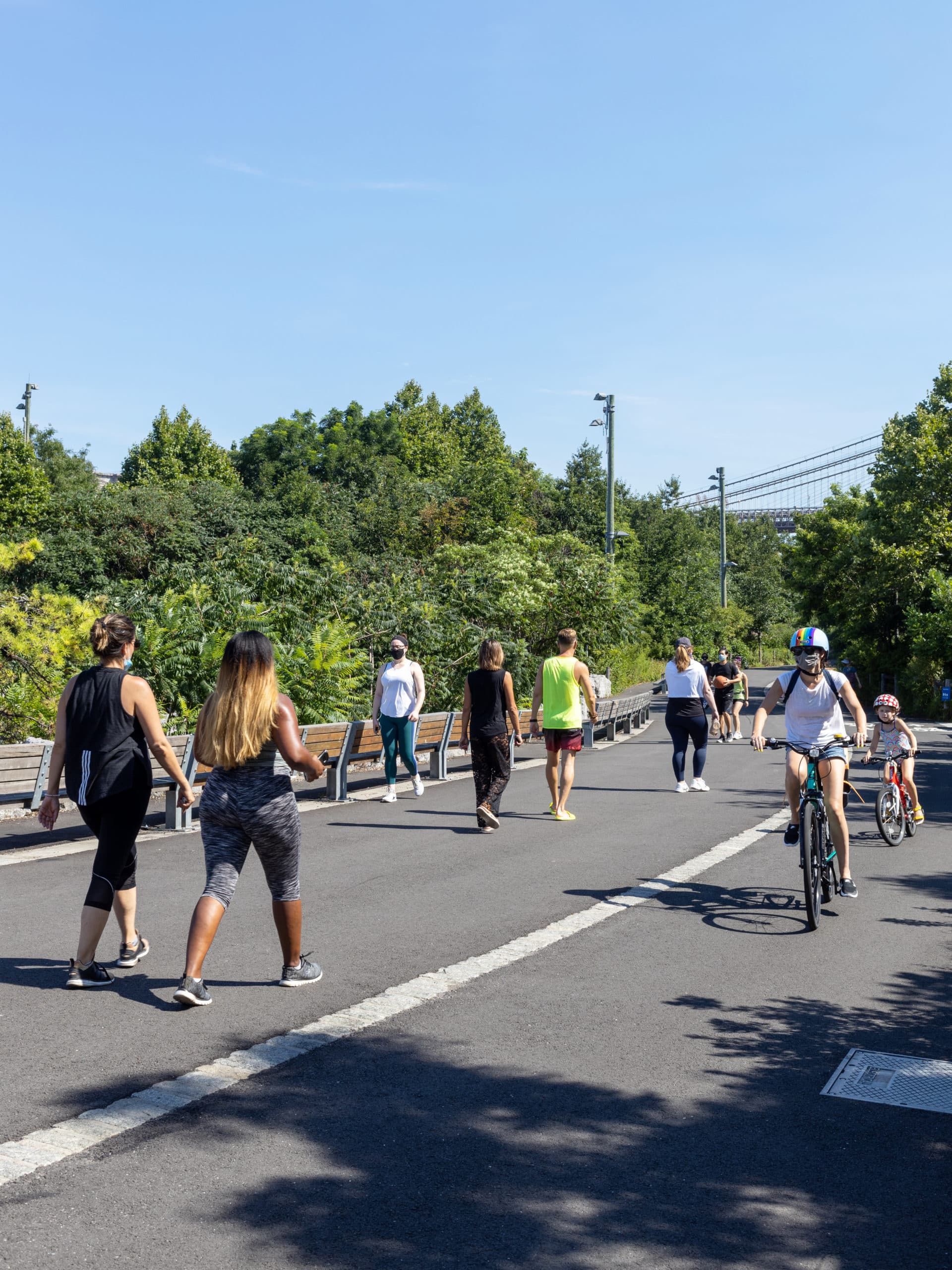 Bikers and joggers on the Greenway on a sunny day.