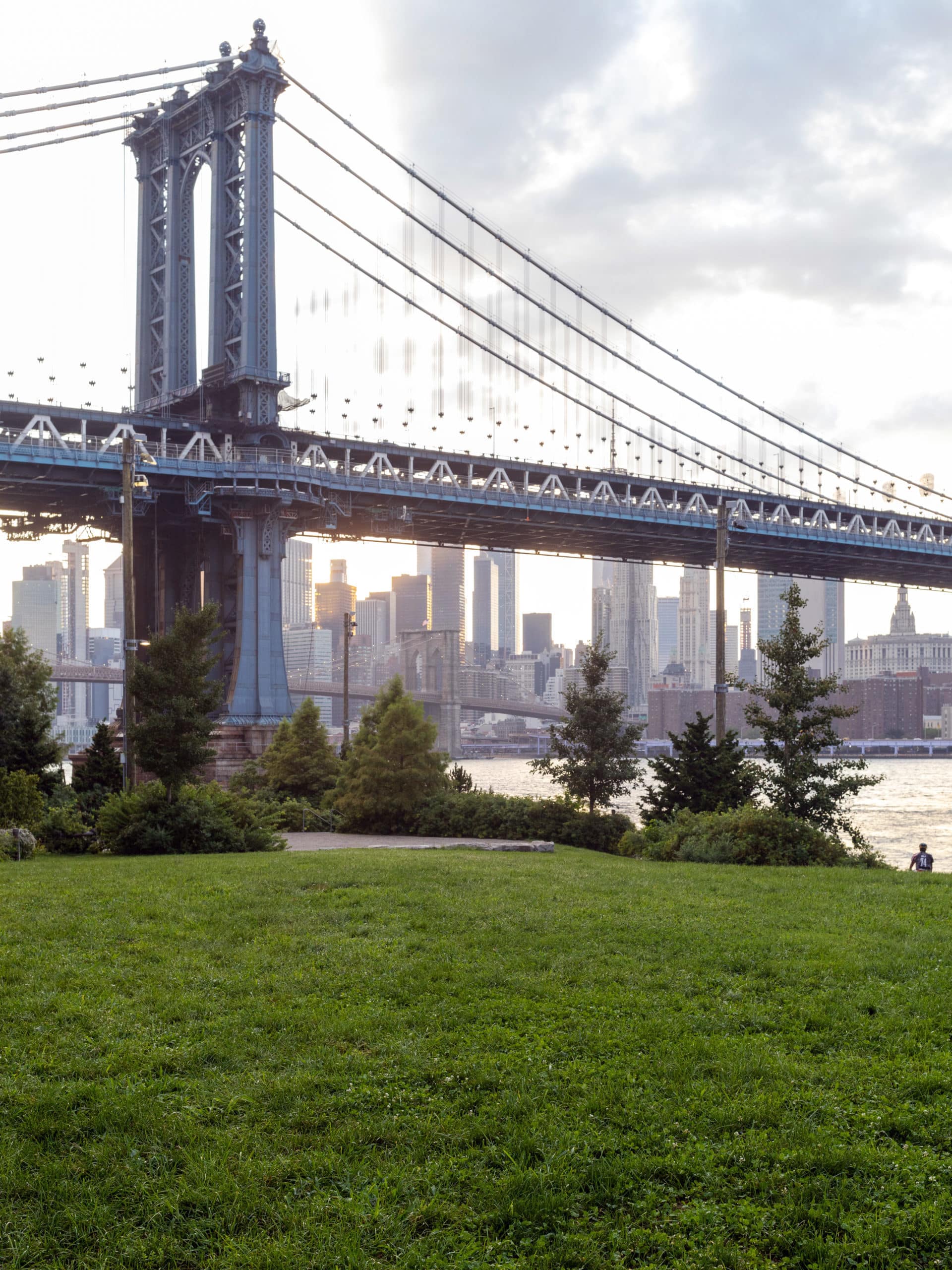 John Street Lawn at sunset with Manhattan Bridge and Brooklyn Bridge in distance.