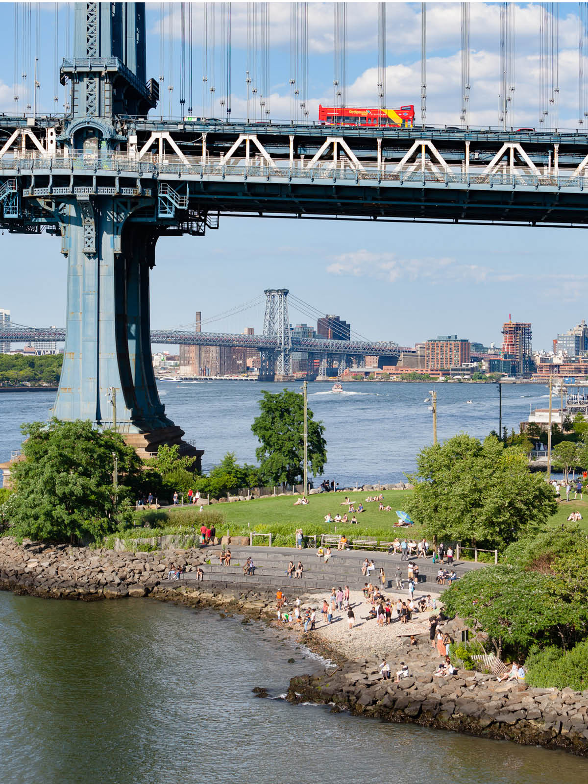 Aerial view of Pebble Beach and Main Street Lawn with the Manhattan Bridge overhead on a sunny day.