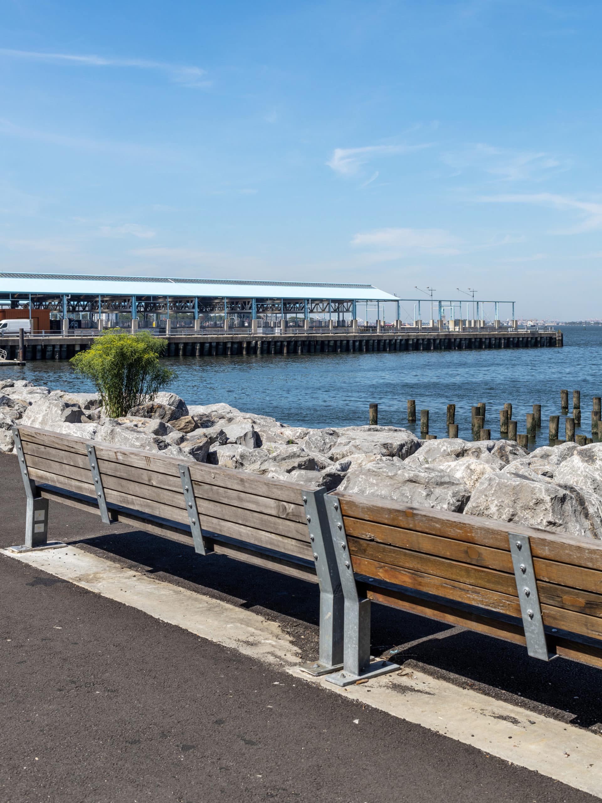 Benches on the pathway overlooking the water with a view of Pier 2.