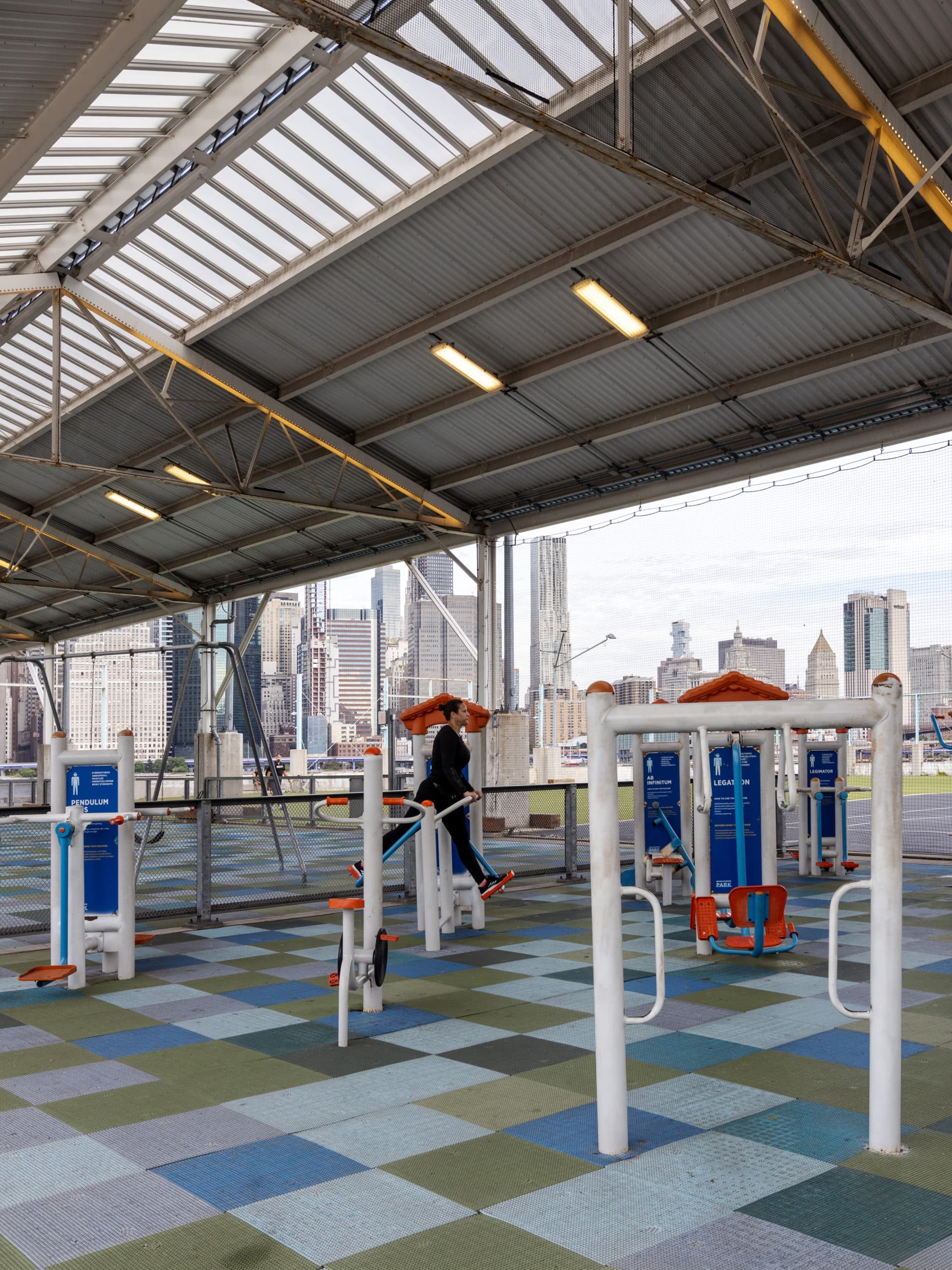 Woman using the fitness equipment under the Pier 2 canopy on a cloudy day.