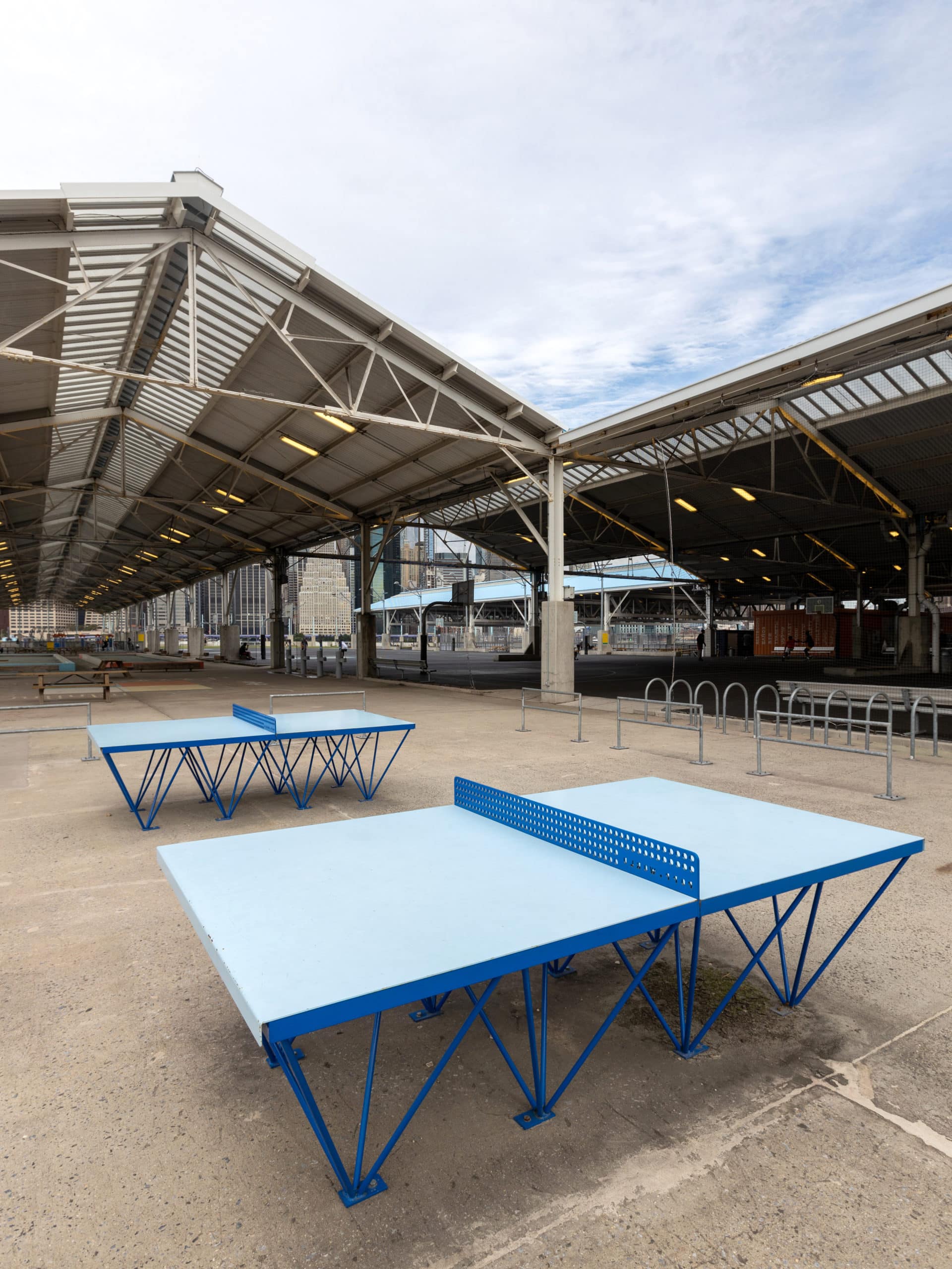 Blue ping pong tables at the courts on Pier 2 on a cloudy day.