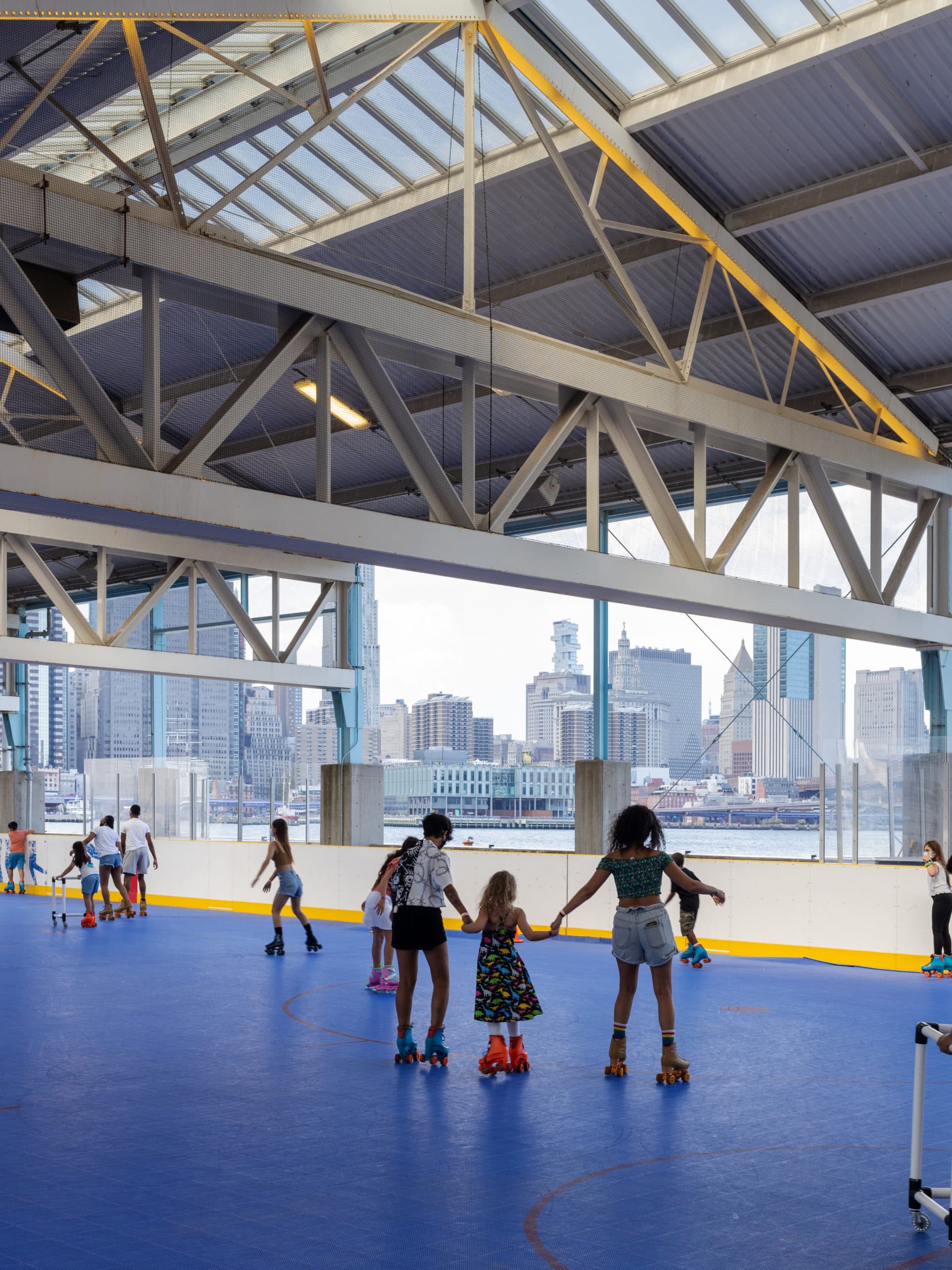 Trio skating holding hands under the roof at Pier 2.