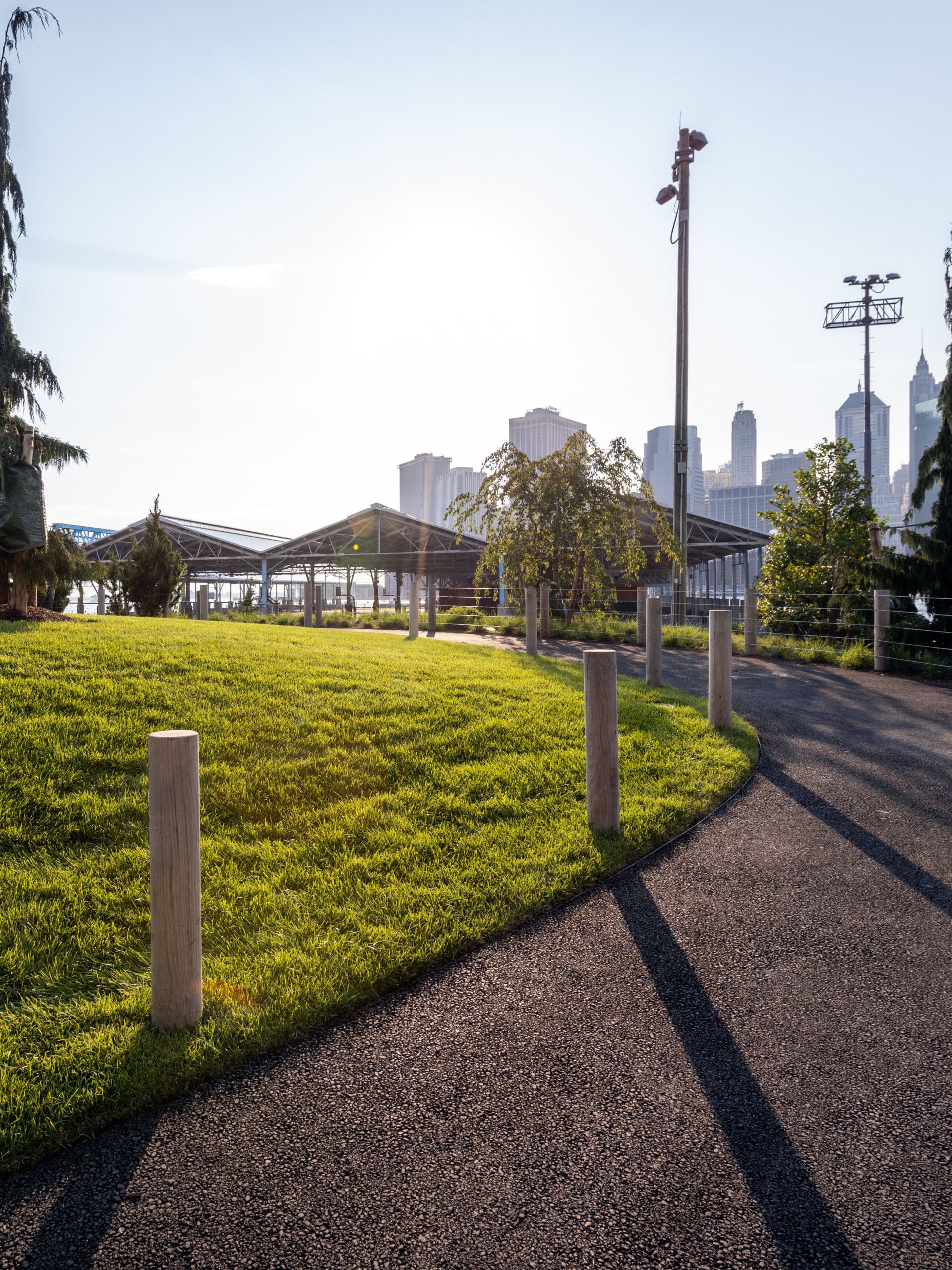 Pathway and lawn in the Pier 2 Uplands with Pier 2 in the distance at sunset.