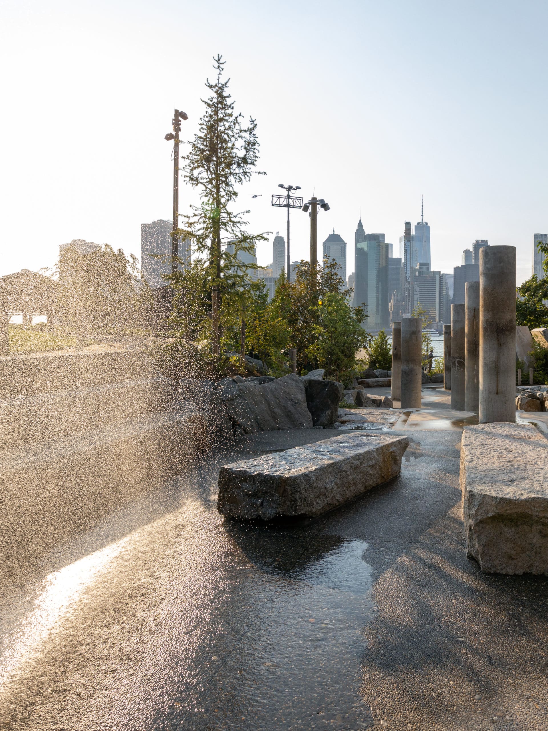 Water spraying at the Water Area at sunset with view of lower Manhattan.