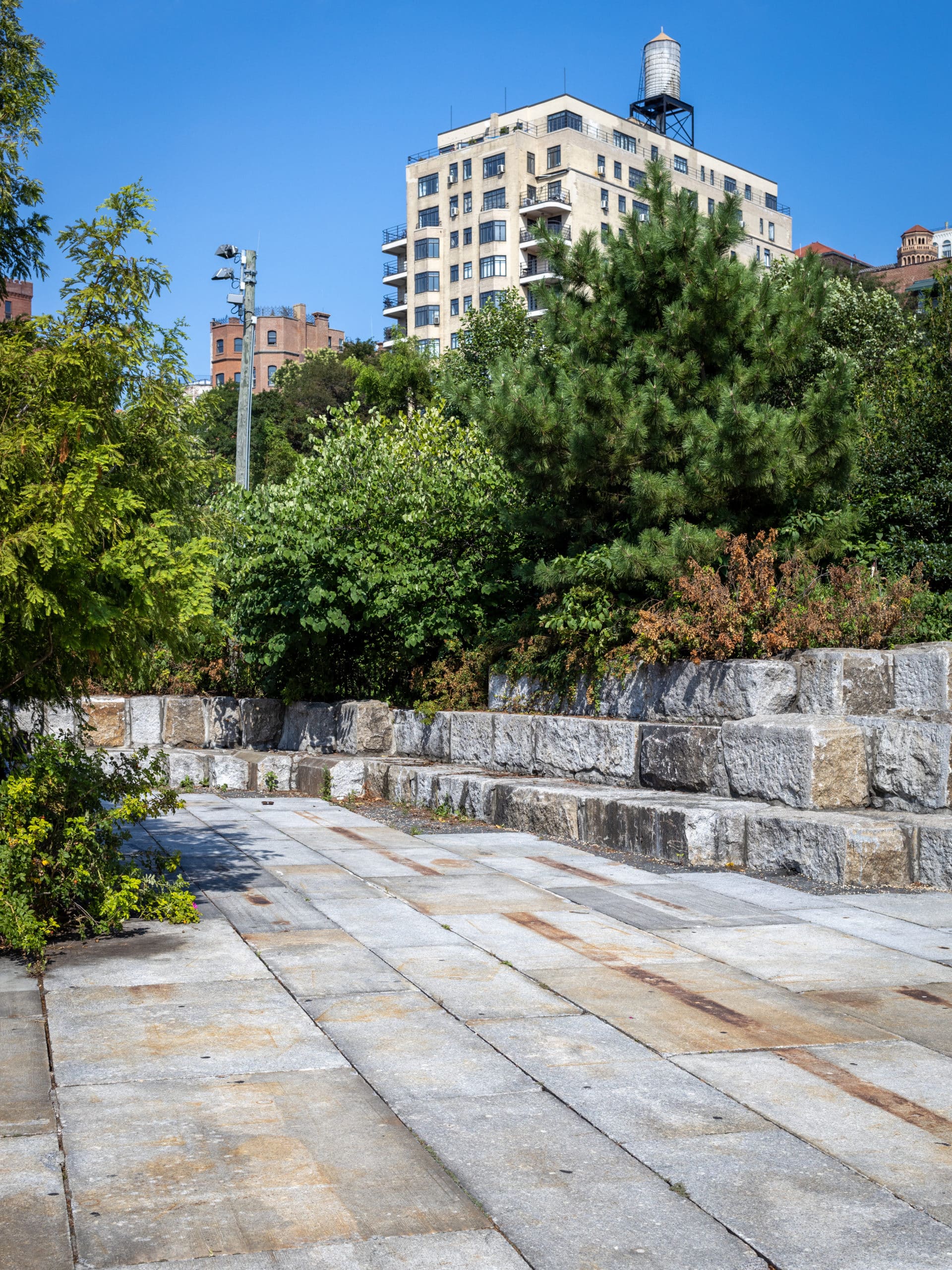 Stacked granite blocks under the trees on the Granite Terrace on a sunny day.