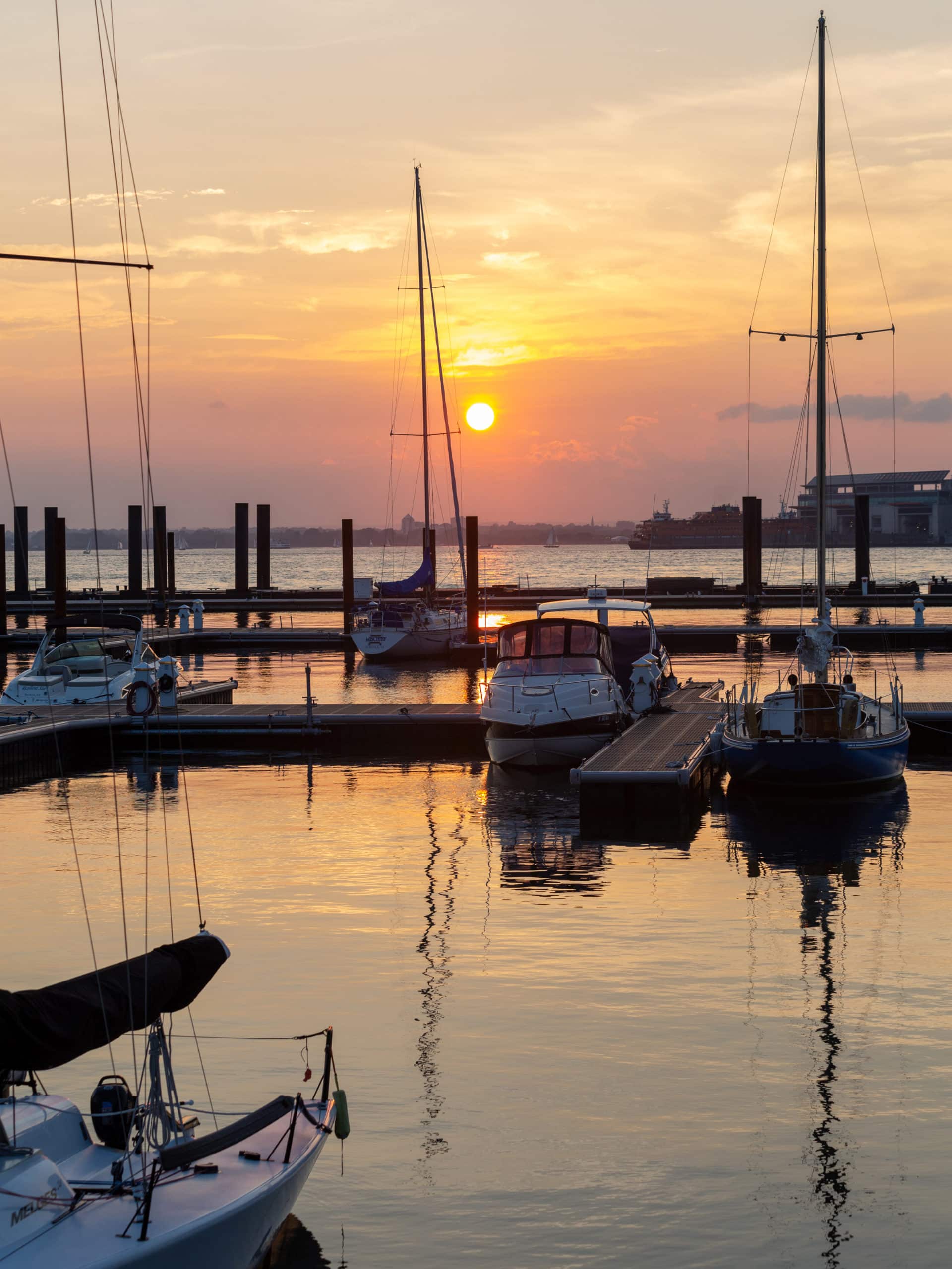 Sailboats docked at ONE°15 Brooklyn Marina at sunset.