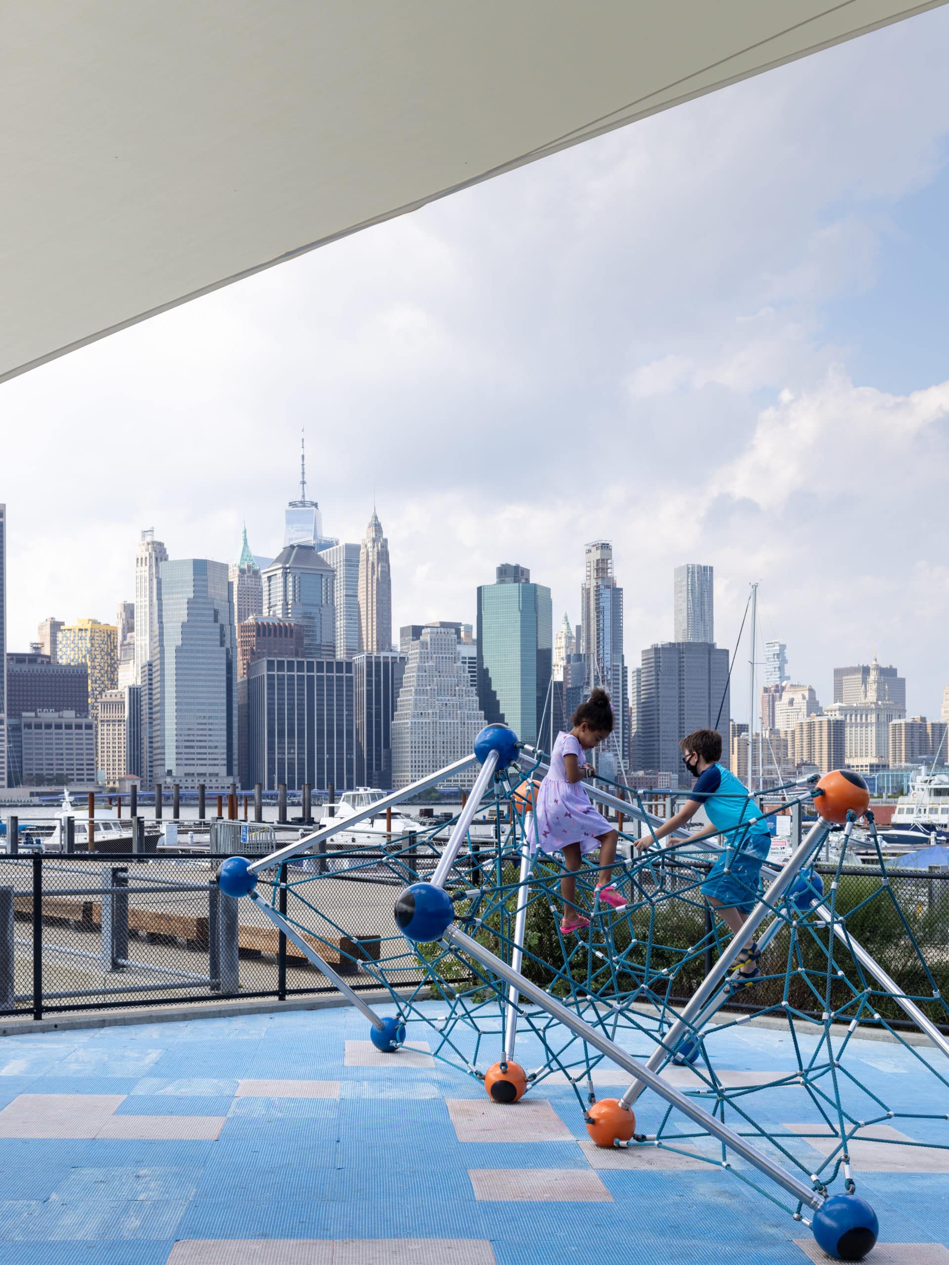 Children playing on climbing structure at Pier 5 Playground on a cloudy day.