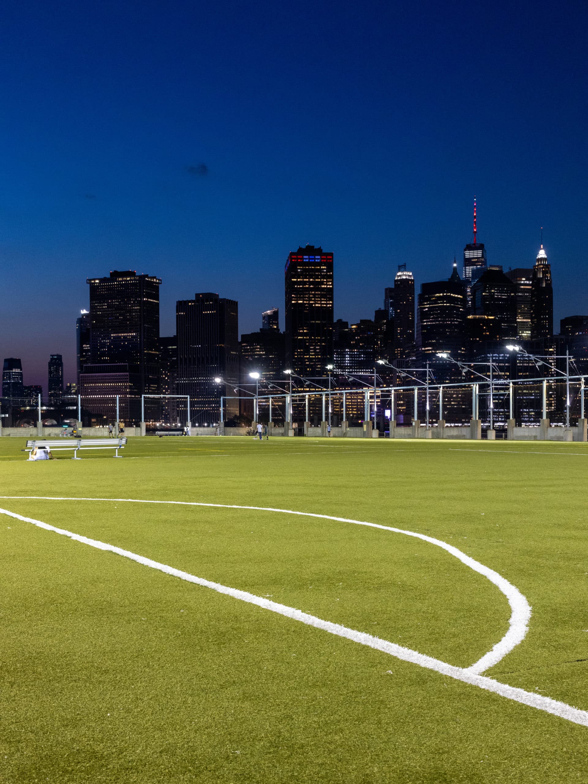 Pier 5 Sport Fields at night with lower Manhattan in background.