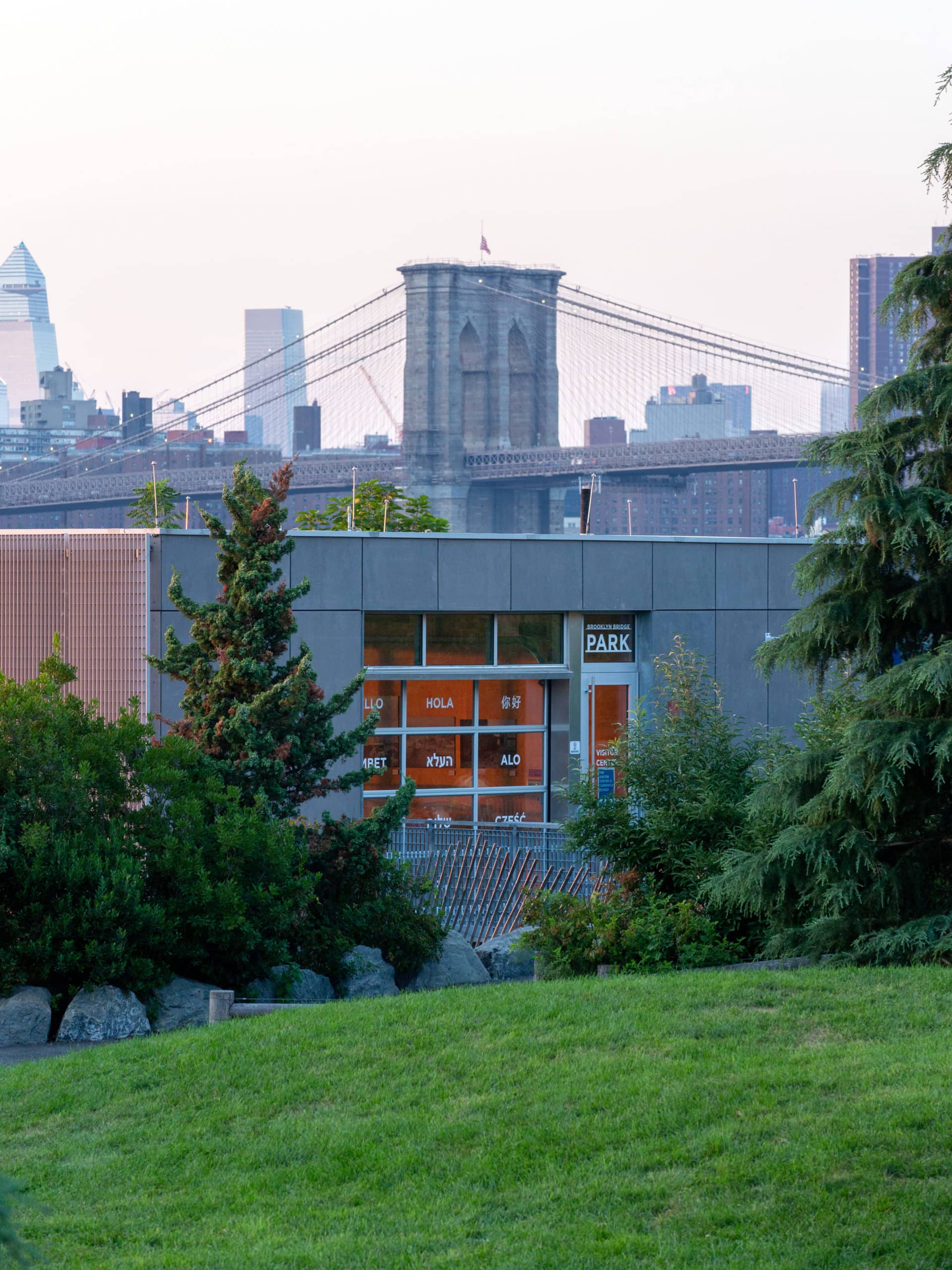 Pier 5 Uplands Lawn in front of the Visitor Center at sunset, with the Brooklyn Bridge in the background.