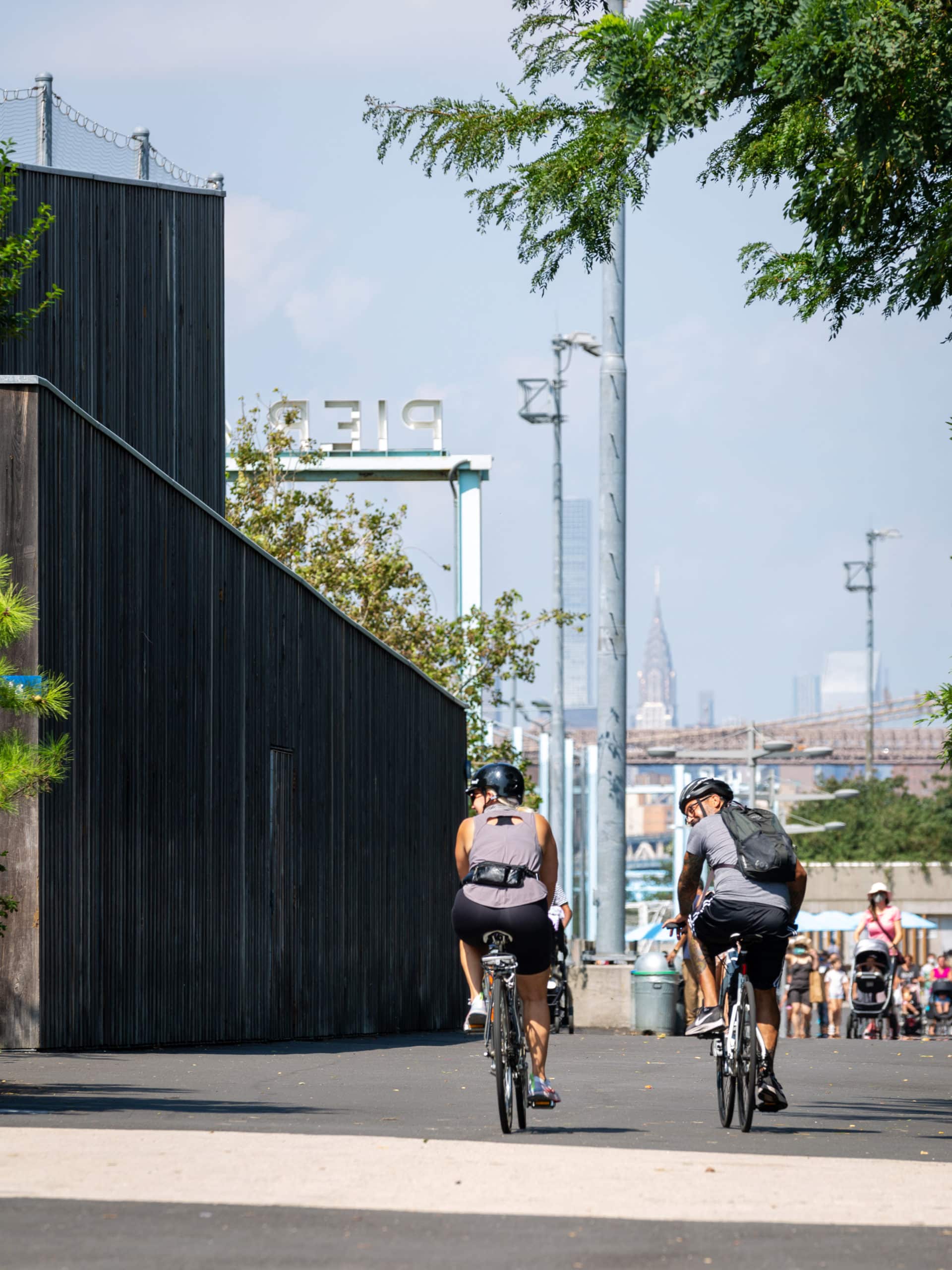 Two people biking beside Pier 6 on a sunny day.