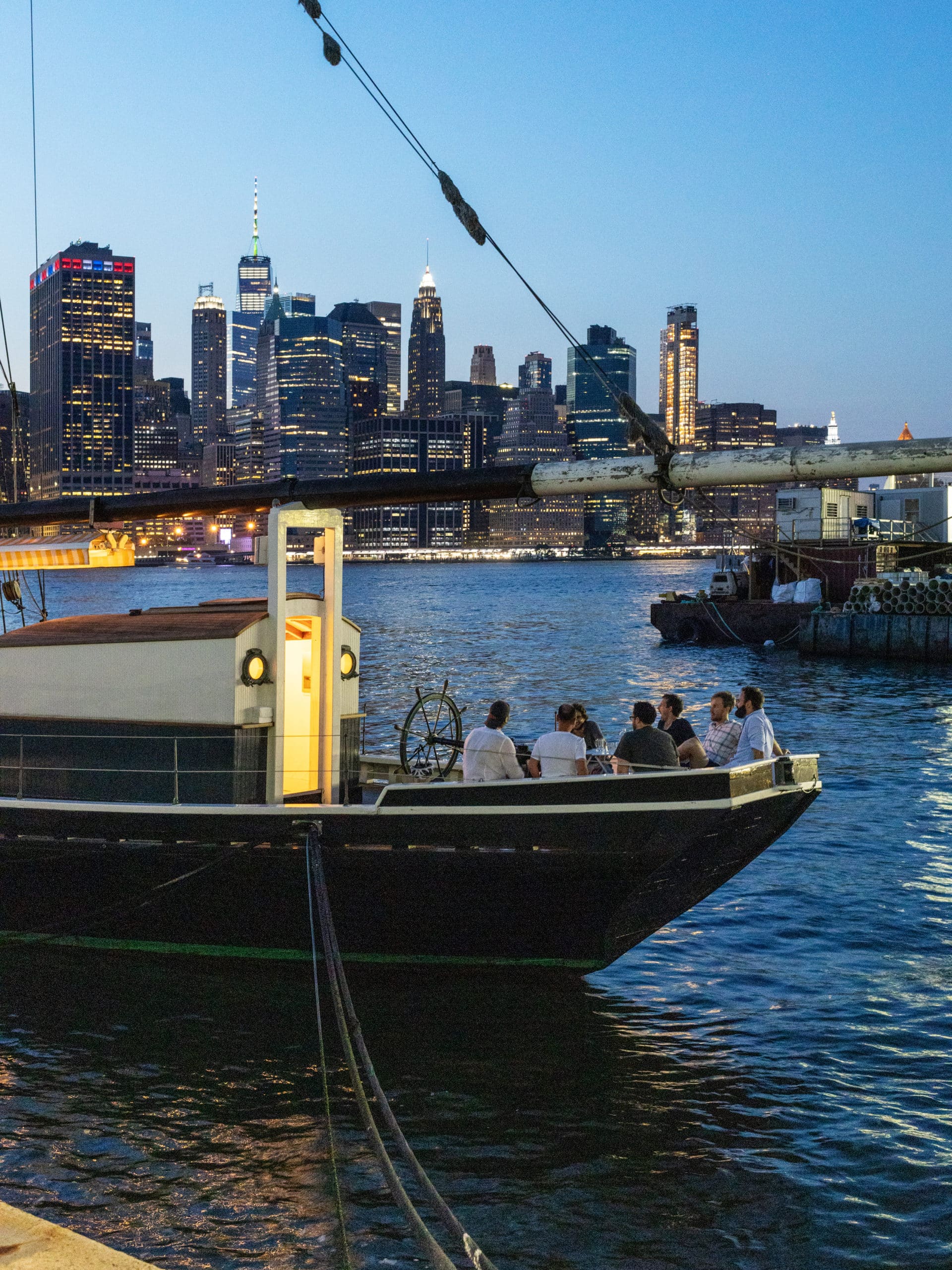 Diners on prow of restaurant boat Pilot at night.