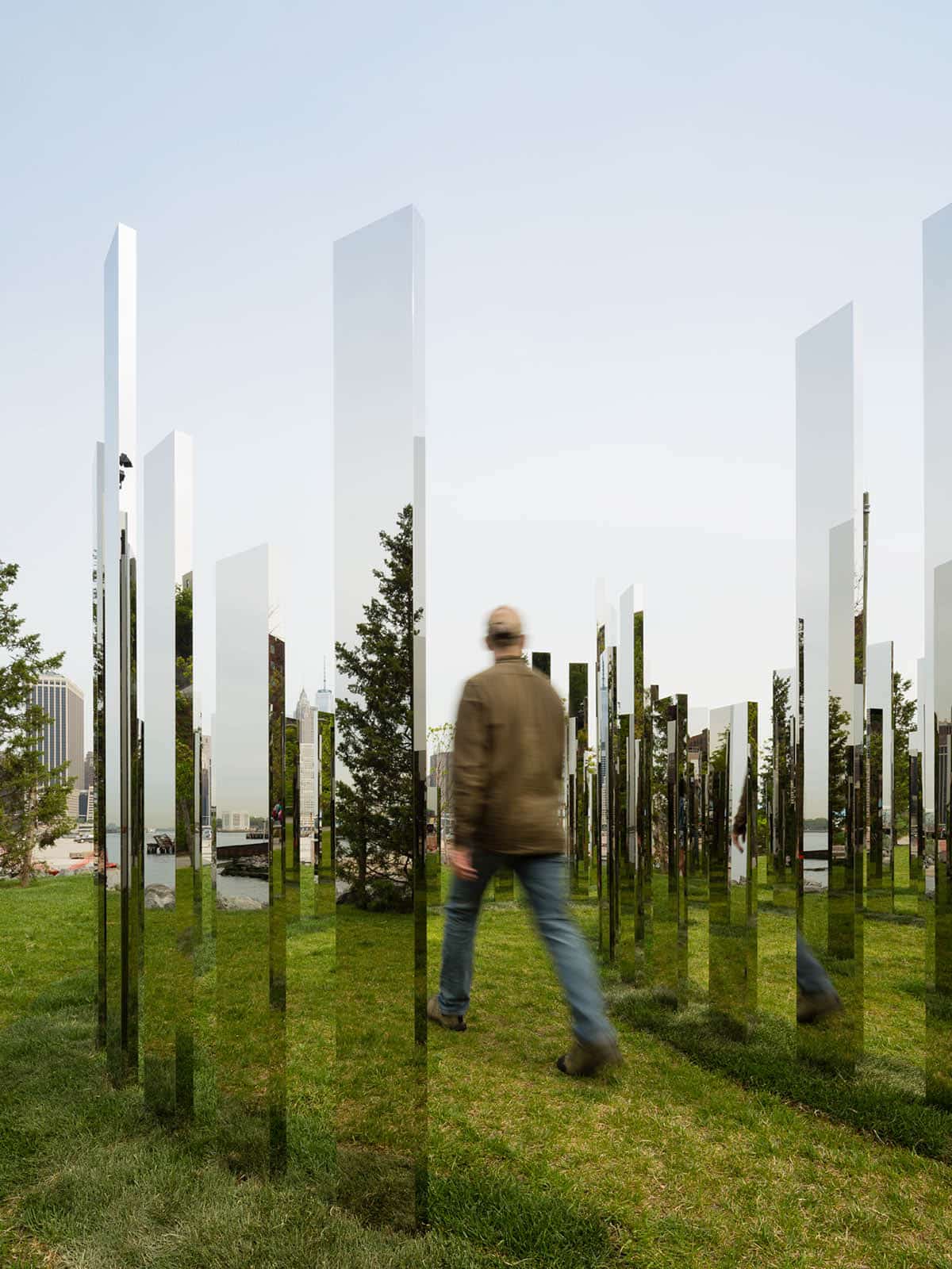 Man walking through standing mirrors in Jeppe Hein's Mirror Labyrinth