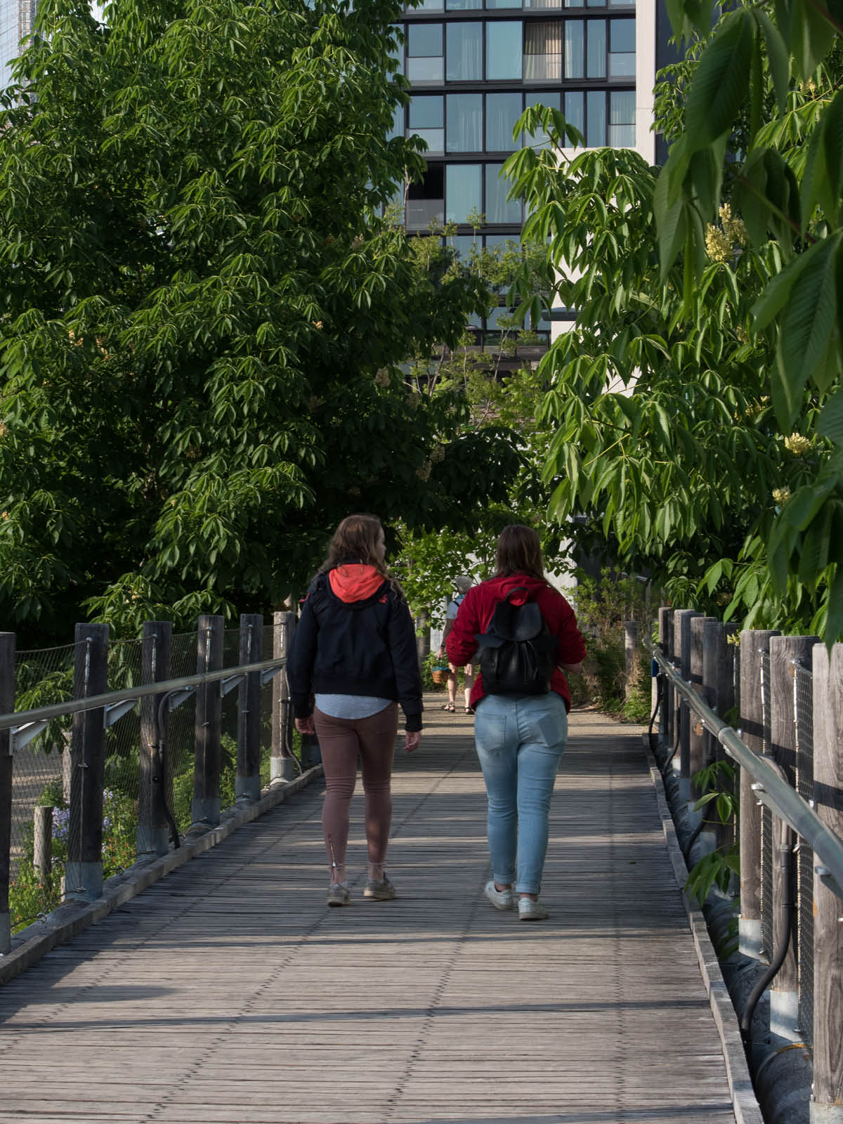 People walking along Squibb Bridge on a sunny day.