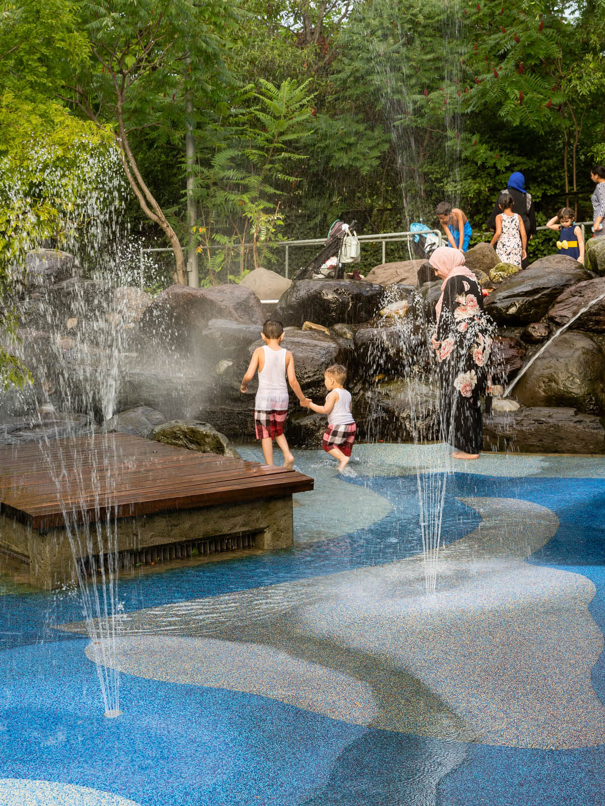 Two children running through the water fountains at Pier 6 Water Lab.