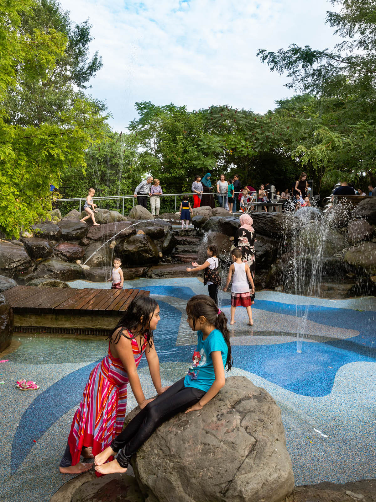 Children playing in the water fountains at the Pier 6 Water Lab on a cloudy day.