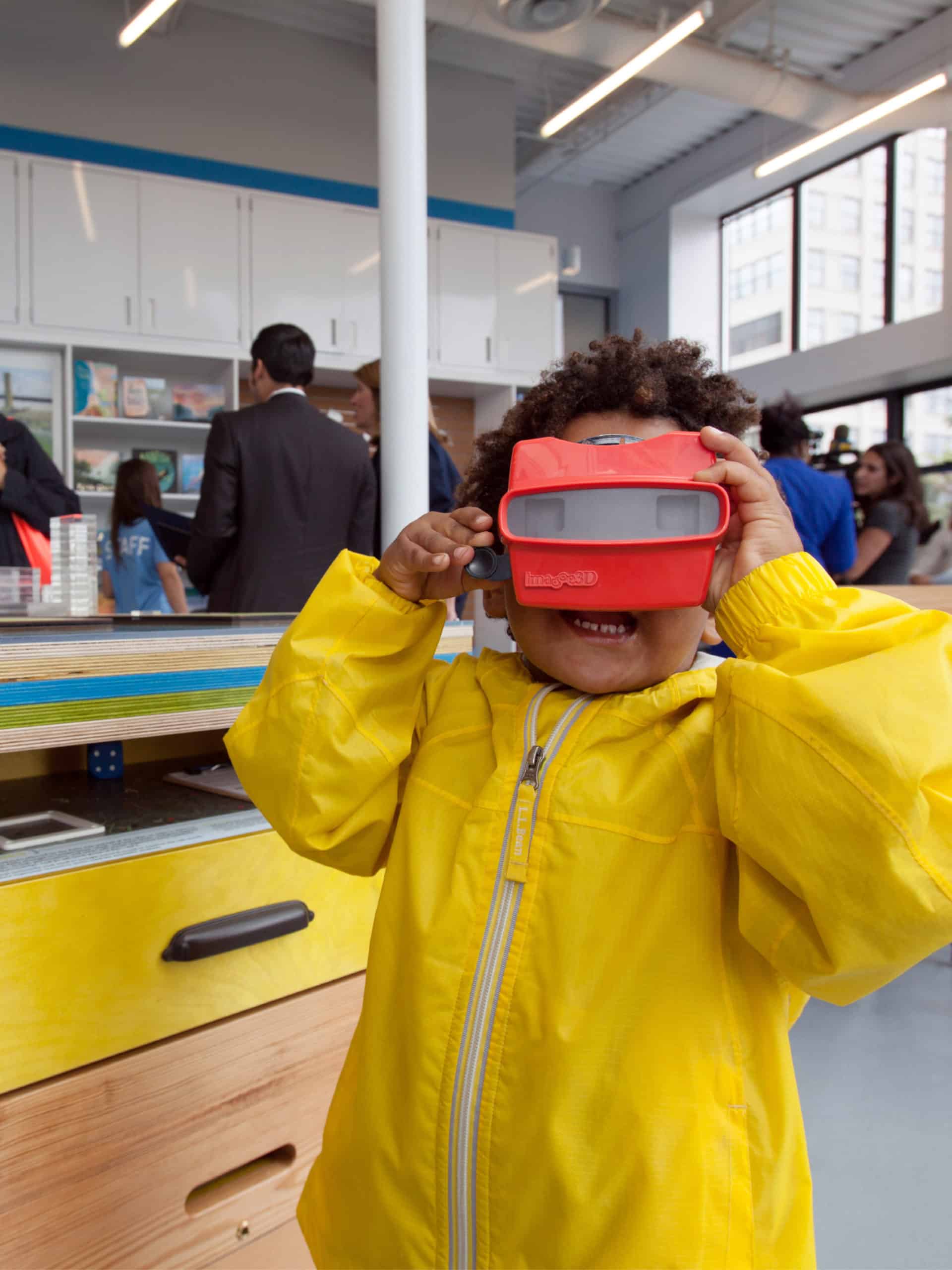 Small child looking through viewmaster in a classroom.