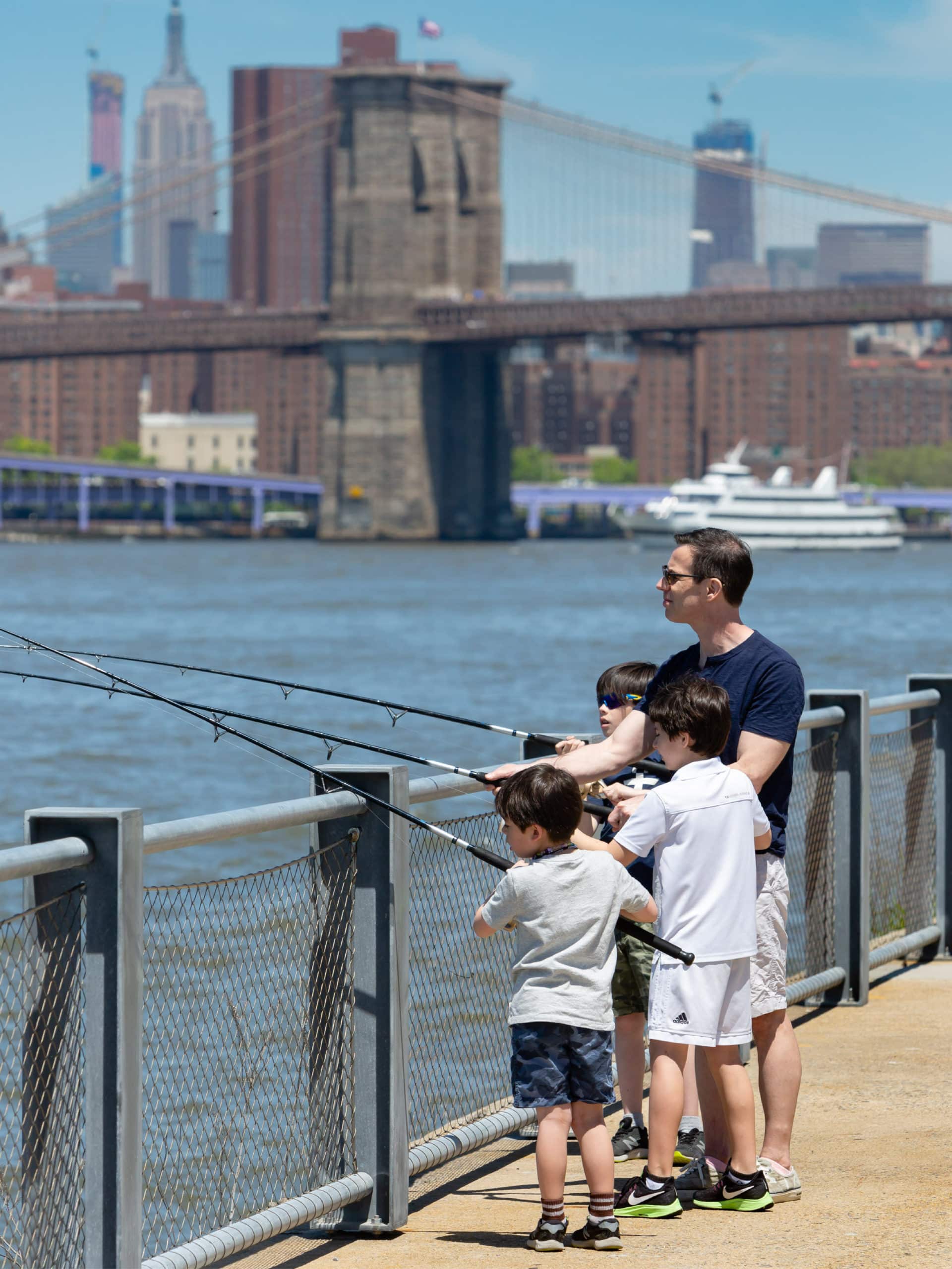 Family fishing on the promenade on a sunny day.