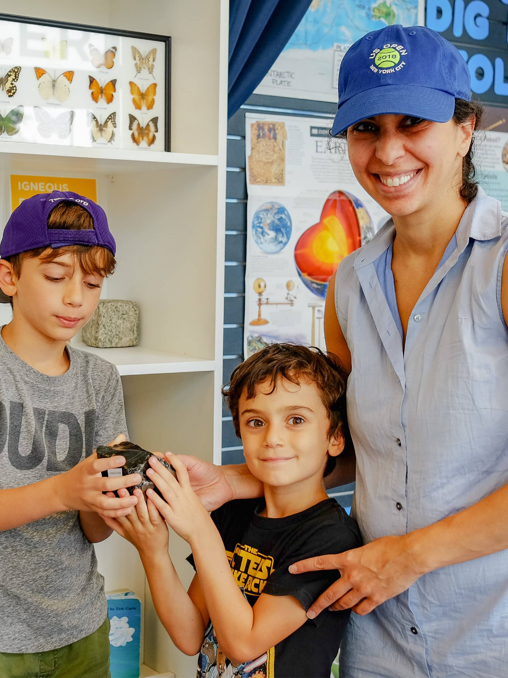 Family holding a rock in a classroom.