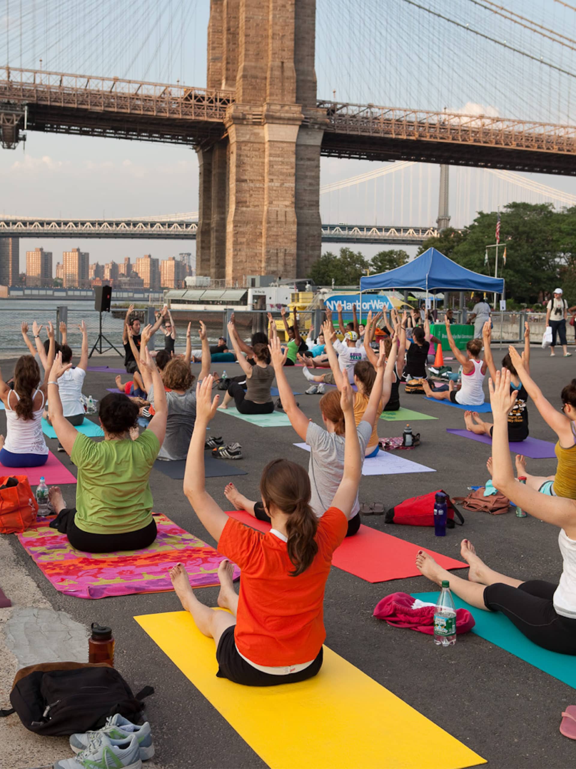 People doing a seated pilates pose on a lawn