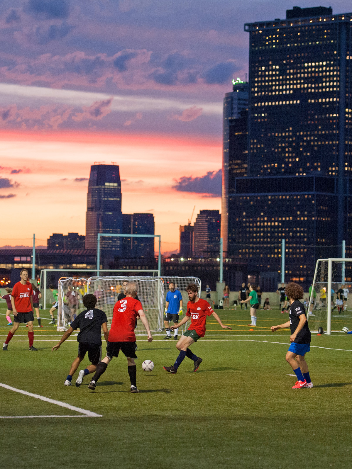 People playing soccer at sunset.