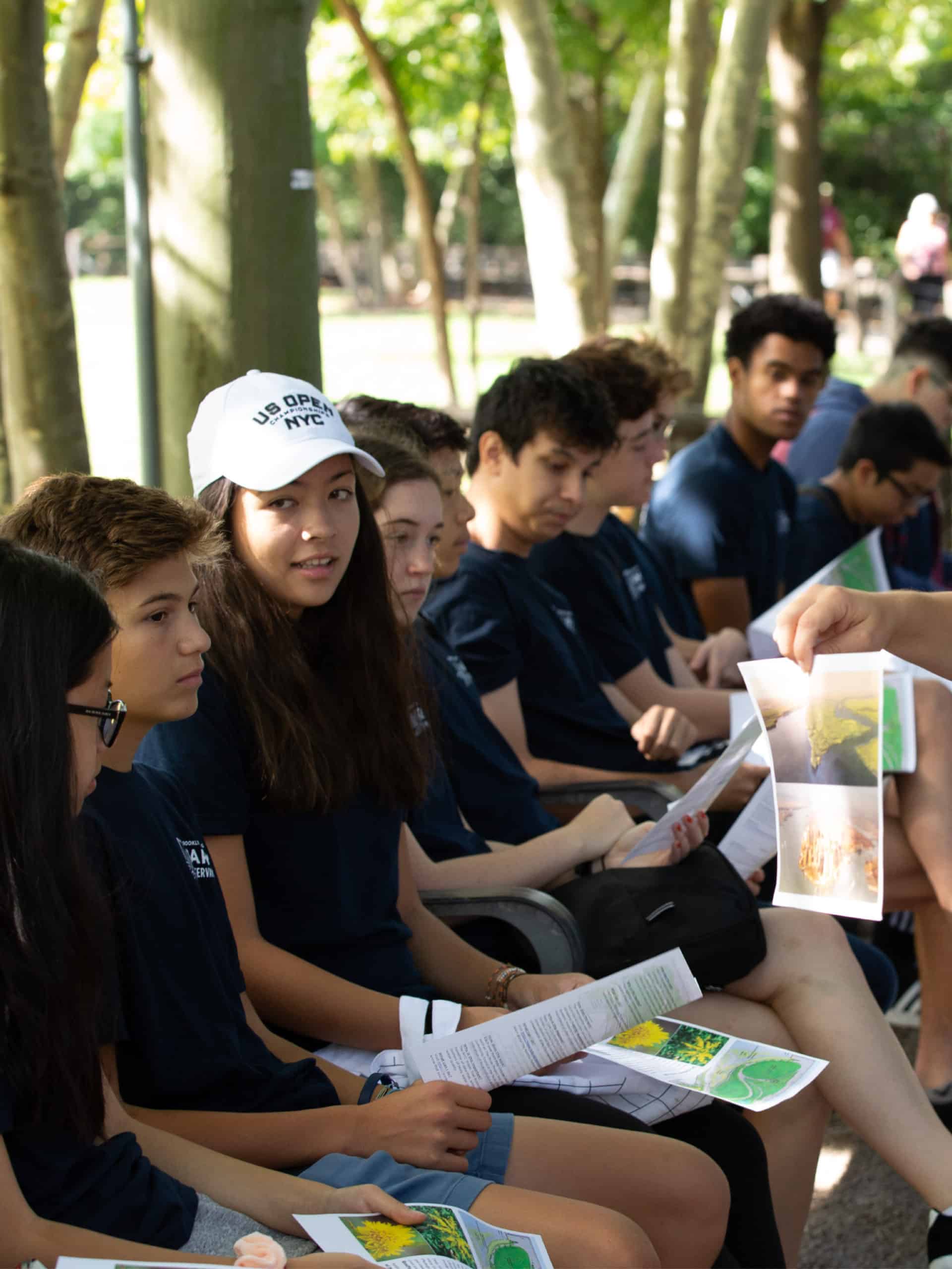 Teens sitting looking at handouts.