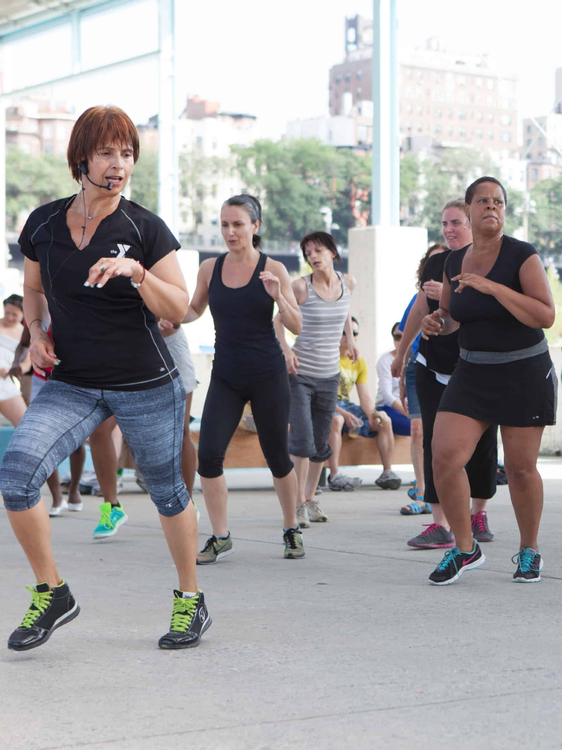 Instructor teaching zumba to a group under the Pier 2 canopy.